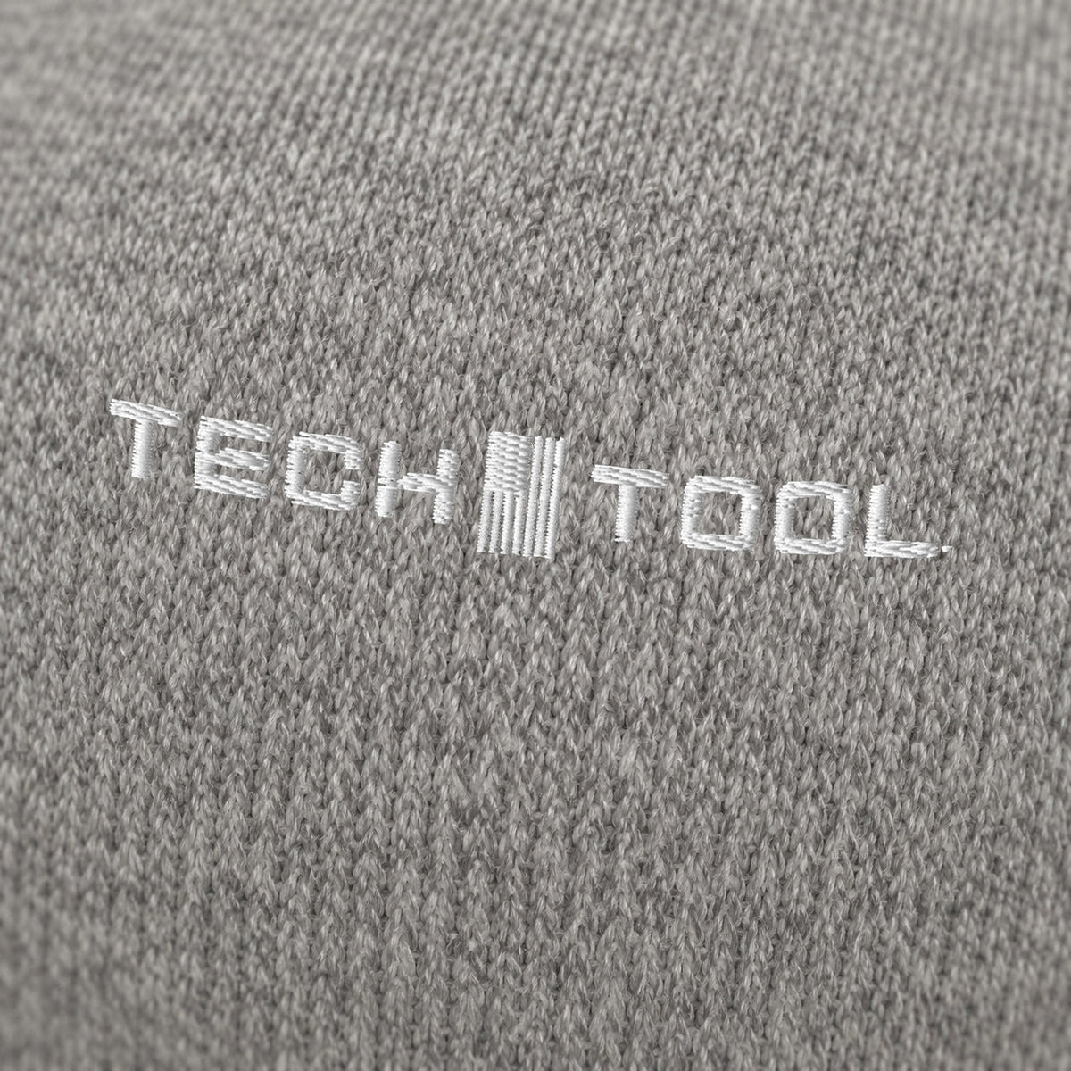 Tech Tool Core Cuffed Beanie, angled macro of white Tech Tool embroidery on fine acrylic knit | Color: Heather Grey