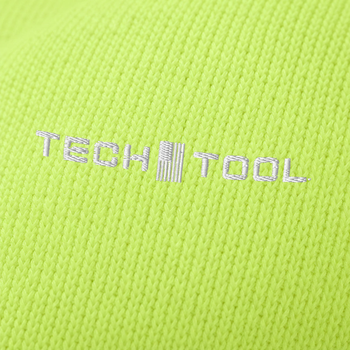 Neon Cuffed Beanie, angled macro of white Tech Tool embroidery on fine acrylic knit | Color: Neon Yellow