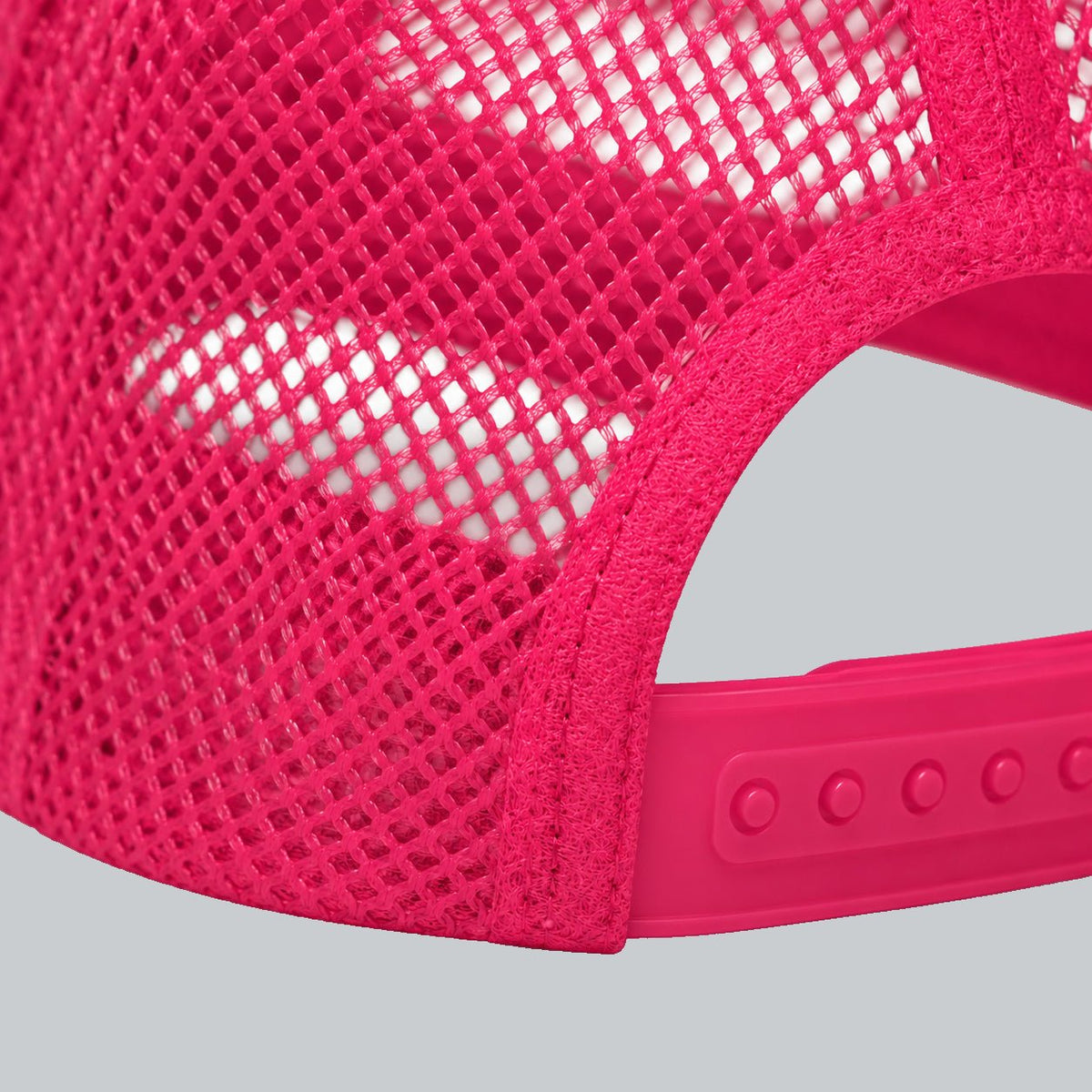 Never a Dull Moment Trucker Hat, oblique macro of mesh, bound back opening and adjustable snap attachment | Color: Flamingo (Hot Pink / White)