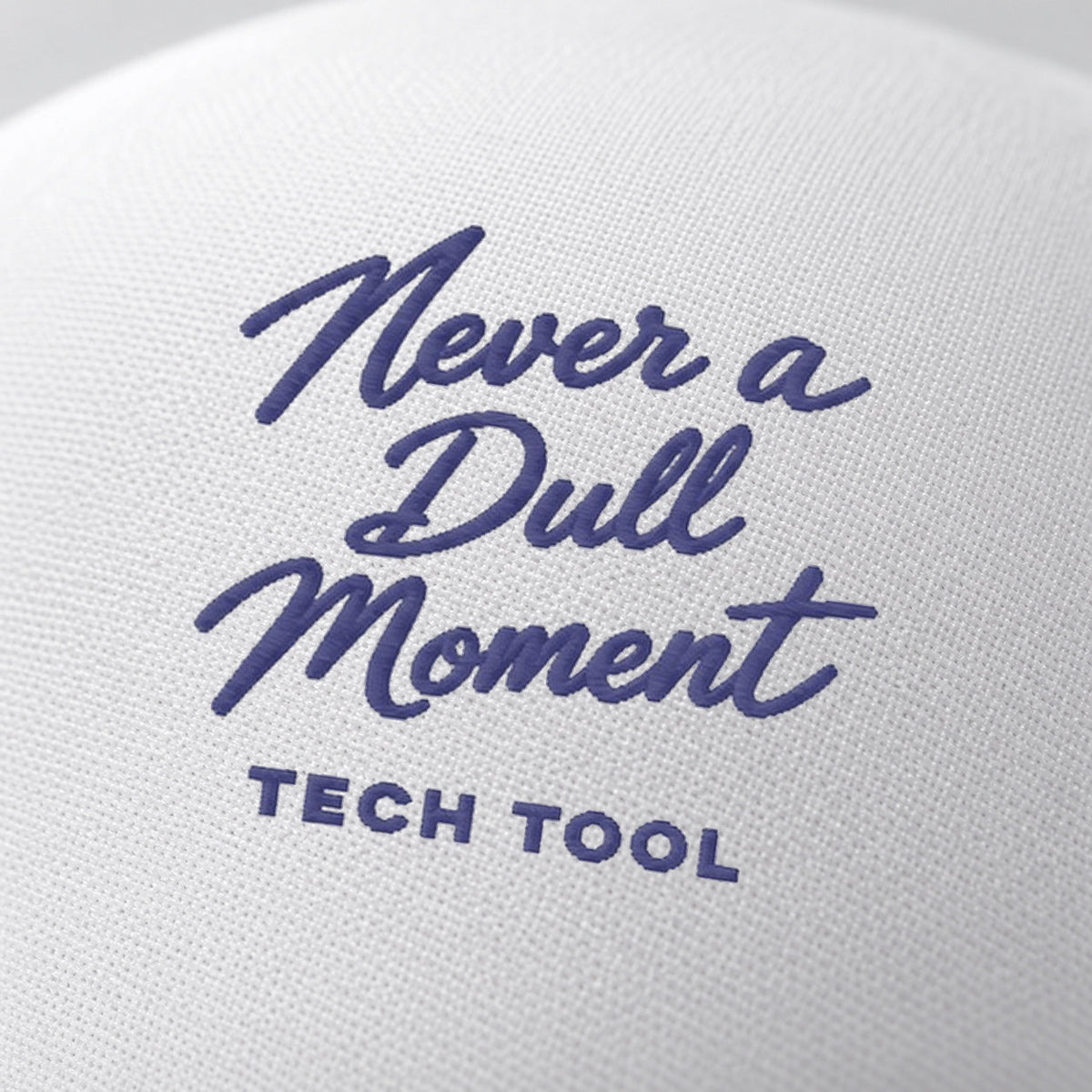 Never a Dull Moment Trucker Hat, oblique macro of Never a Dull Moment script embroidery and Tech Tool signature on white foam | Color: Midnight (Navy / White)