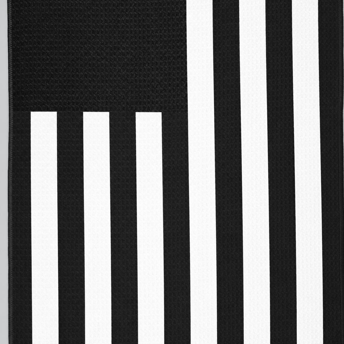 Tech Tool Signature Golf Towel in Black, close view of flag stripes and hem | Color: Black